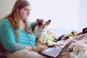 A 19-year-old woman with Autism and other A 19 year old autistic woman using her laptop at home for school.