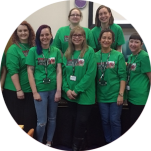 A group of FTWW Volunteers, wearing green t-shirts, smile at the camera.